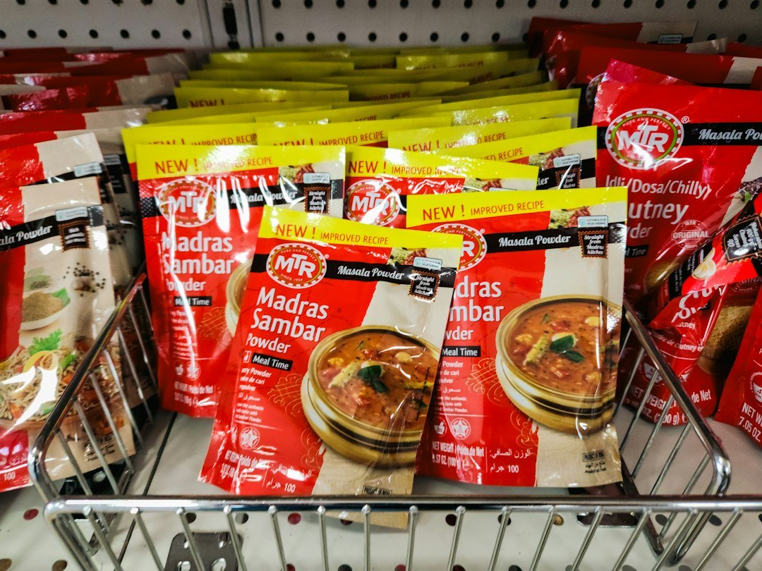 Rows of red spice packets in a wire basket on a store shelf